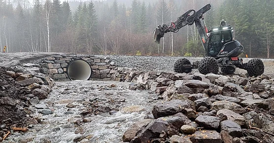 Menzi muck maskinen ved natursteinsmur rundt kulvert for elv gjennom vei