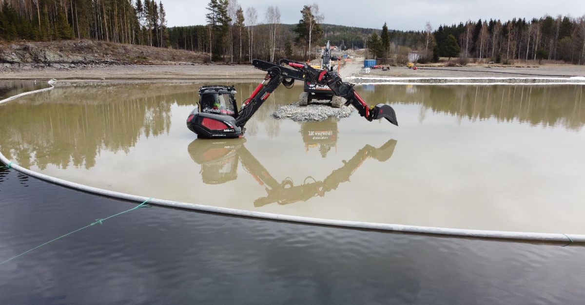 Menzi Muck maskin står i vann og graver