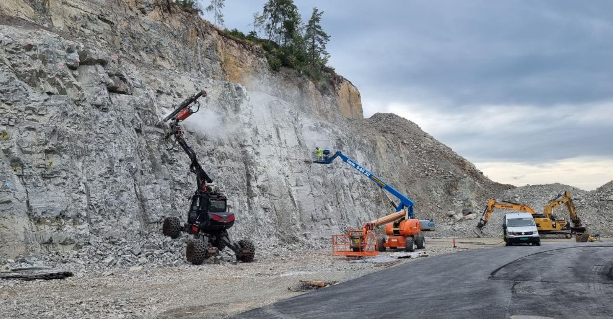 Menzi muck maskin borer i fjellvegg