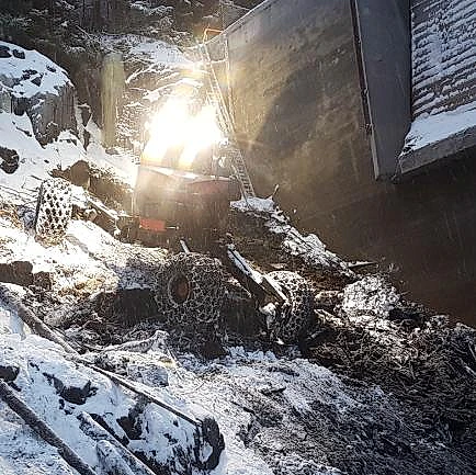 Menzi Muck maskin med lys i snødekt bakke