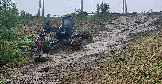 Menzi muck i skråning graver i jord